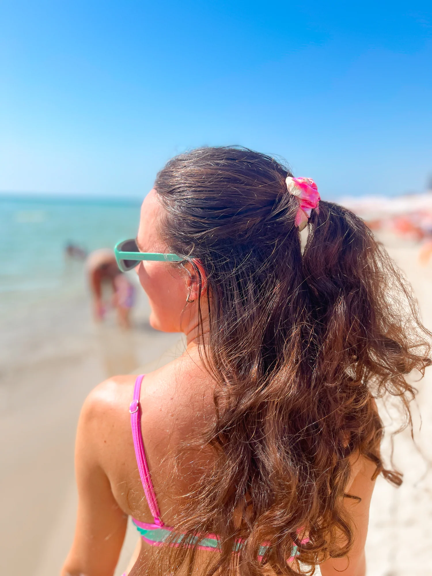 Woman wearing a handmade waterproof swim scrunchie at the beach